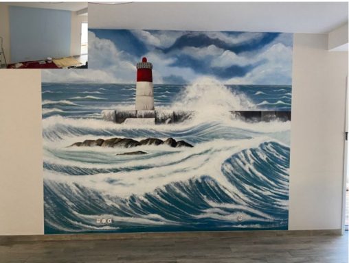 Mural en trompe oeil en intérieur Fresque représentant un phare surmonté de vagues déferlantes en bord de mer.