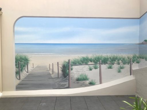 Fresque représentant un sentier menant à une plage avec du sable et des dunes de végétation.