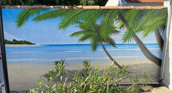 Plage tropicale avec palmiers et mer bleue sous un ciel ensoleillé.