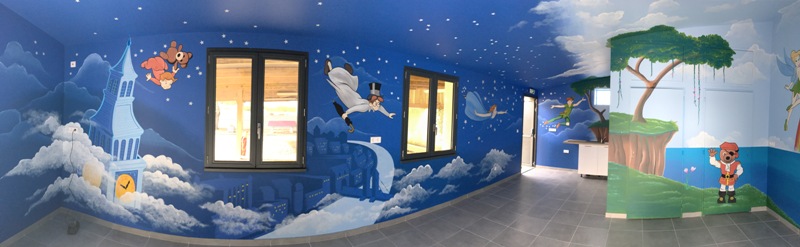 Mur décoré de fresques colorées représentant des paysages et des animaux.