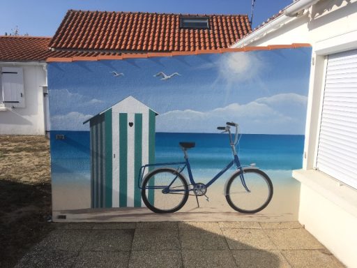Bicyclette bleue devant un cabanon de plage sur fond marin.